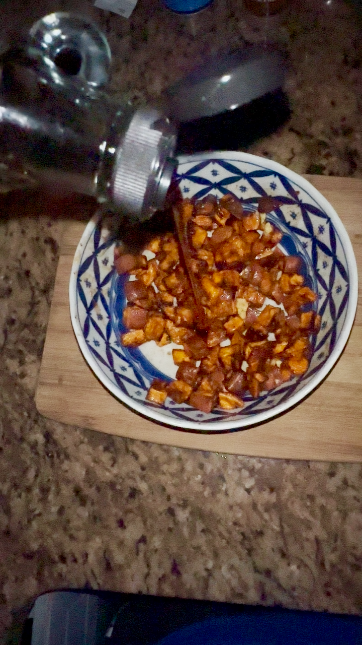 sweet potatoes in a bowl with butter, maple syrup, cinnamon, nutmeg