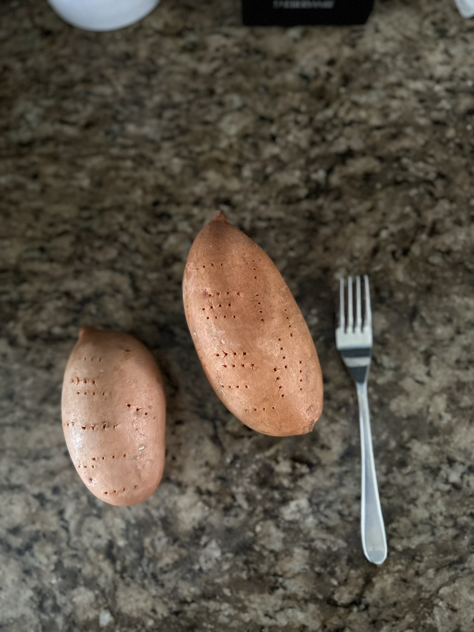 2 sweet potatoes next to a fork